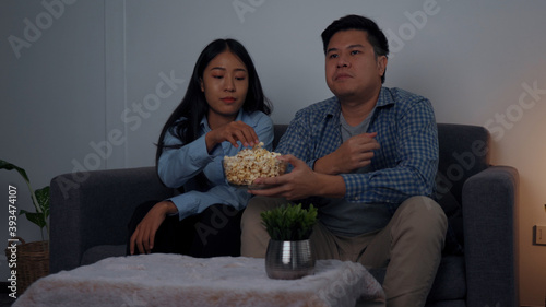 Asian couples watch movies on TV on weekends at night.
