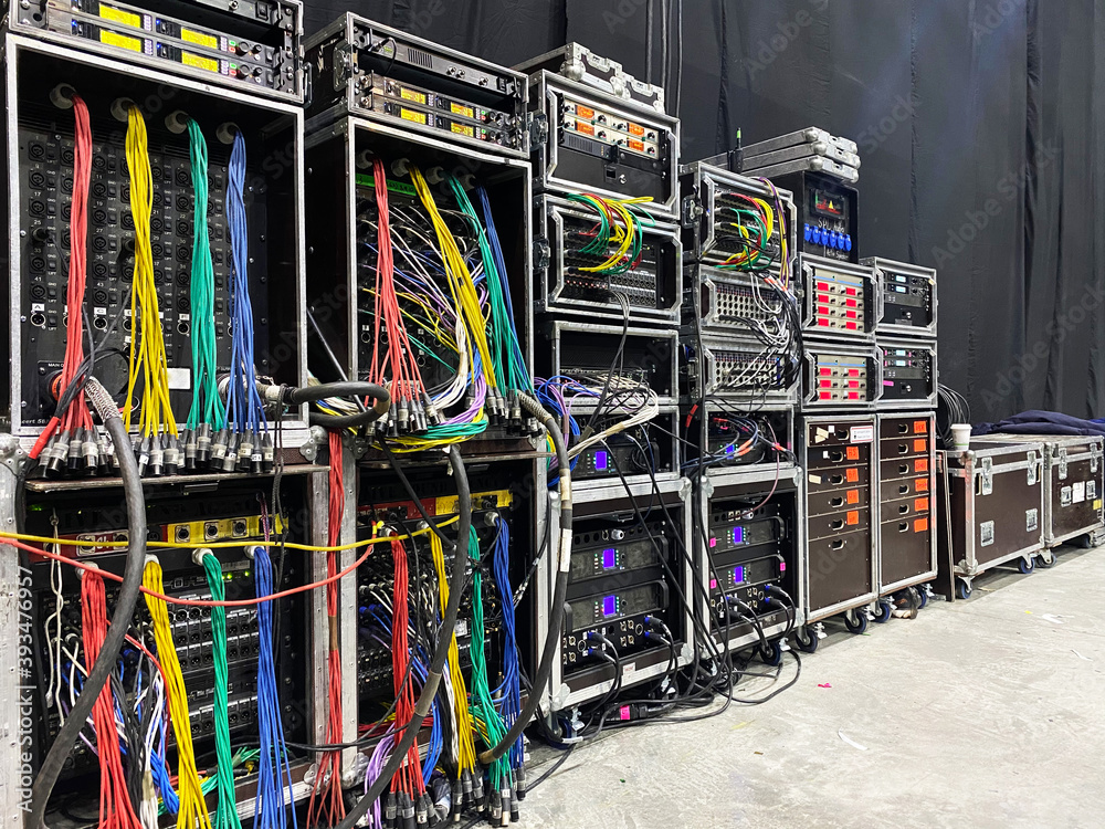 Backstage area and tech zone with rack amplifiers, signal splitters, flight cases and radio microphone systems. Professional sound equipment for a concert.