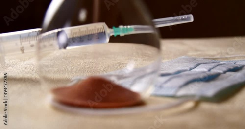 syringe with injection and face mask and hourglass