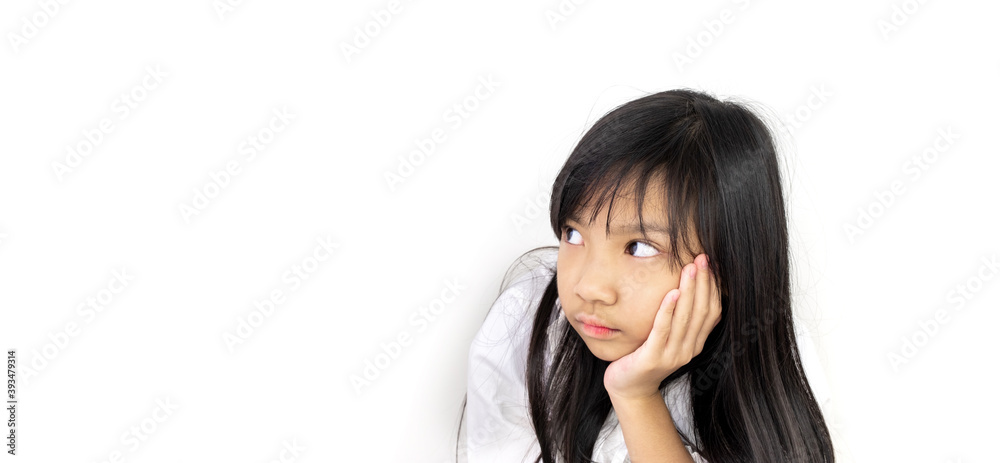 Asian child girl wearing a white shirt and holding her chin in hand is thinking or worried about something. Asian child girl wearing a white shirt and holding her chin in hand is thinking or worried about something.