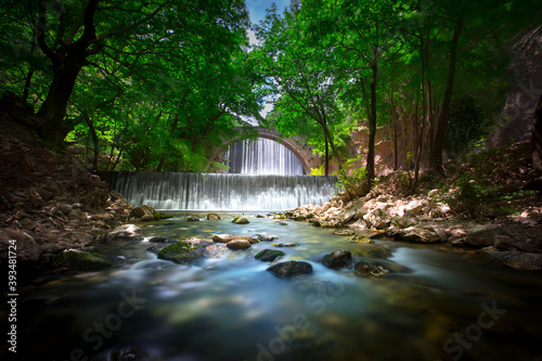 A small waterfall just behind the stone bridge of Palaiokarya, creating an impressive combination. photo