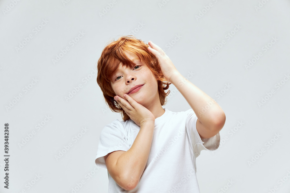 cute redhead boy holding hands on face white t-shirt studio cute redhead boy holding hands on face white t-shirt studio