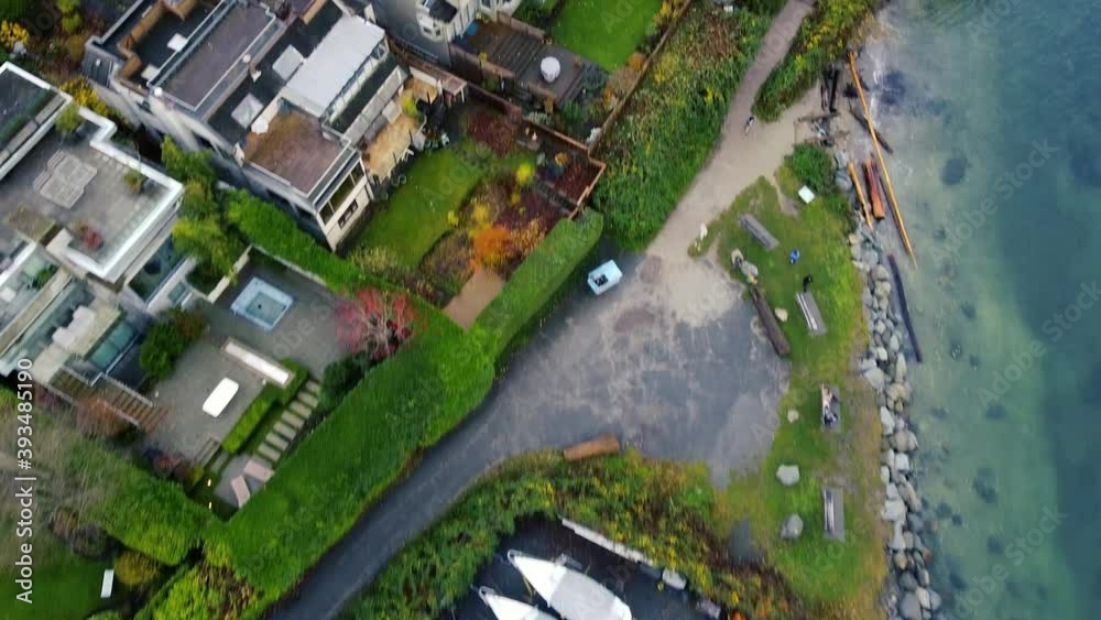 Fly over houses near the water and greenery adjacent Fly over houses near the water and greenery adjacent