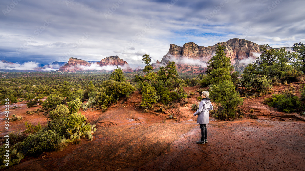 Woman looking at the Red Rocks of Munds Mountain and Surrounding Mountains near the town of Sedona in northern Arizona in Coconino National Forest, USA