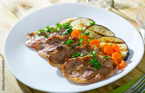 Appetizing grilled lamb chops with vegetable garnish of eggplant, carrots and greens