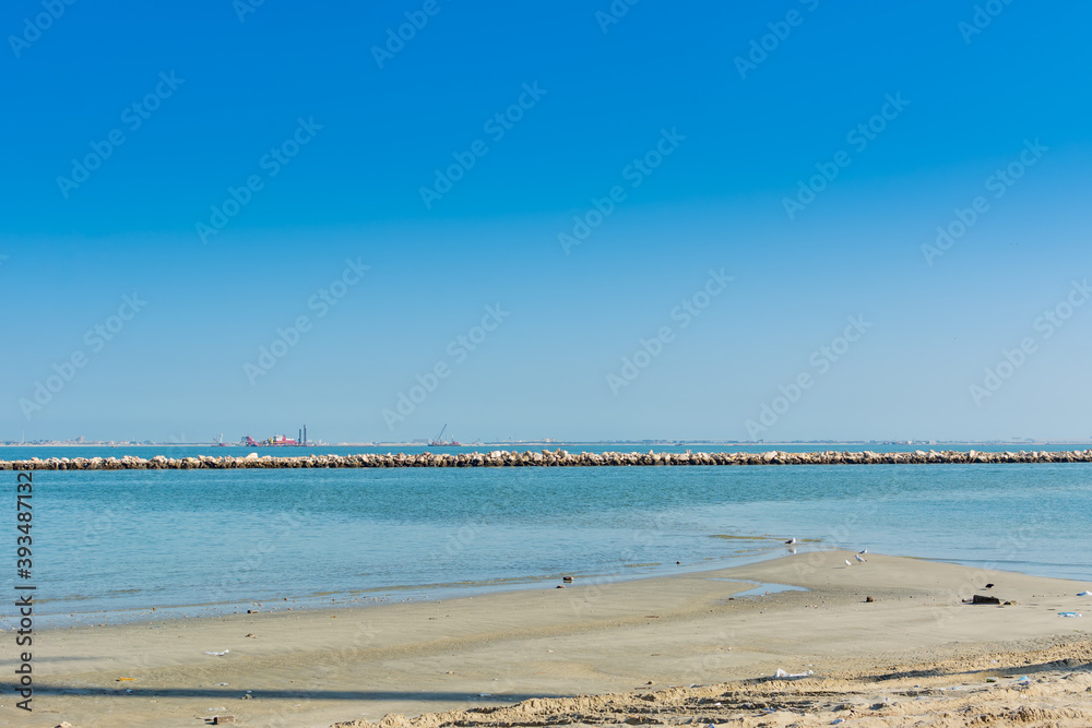 Blue sea and beach with blue sky at the corniche park in Dammam, Kingdom of Saudi Arabia