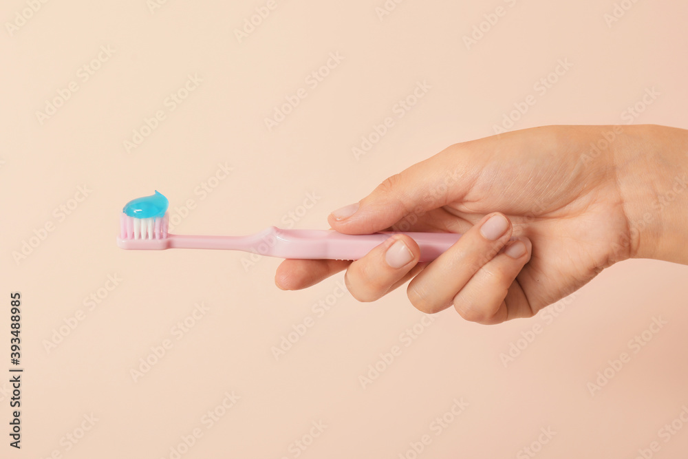 Female hand holding toothbrush on color background Female hand holding toothbrush on color background