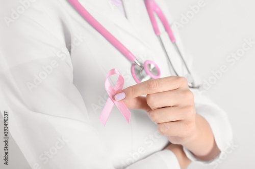 Female doctor with pink ribbon  closeup. Breast cancer awareness concept