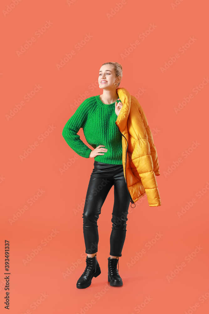 Beautiful young woman in warm clothes on color background Beautiful young woman in warm clothes on color background