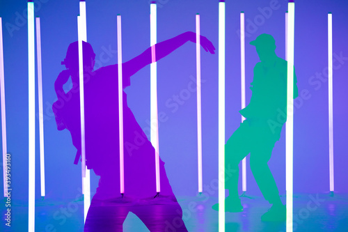 Collage of shadows handsome person doing hip hop elements on neon lamps background. Close up man dancing at party in night club. Dance school poster.
