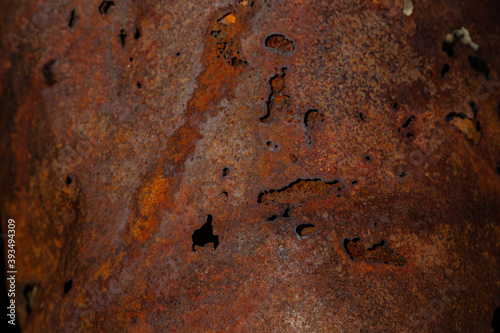 On a rough wall or floor, paint flakes off. Corrosion and rust of metal. Old dilapidated wall.