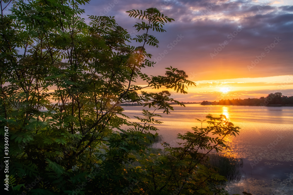 Beautiful peaceful sunset or sunrise panoramic view of water of lake or river.