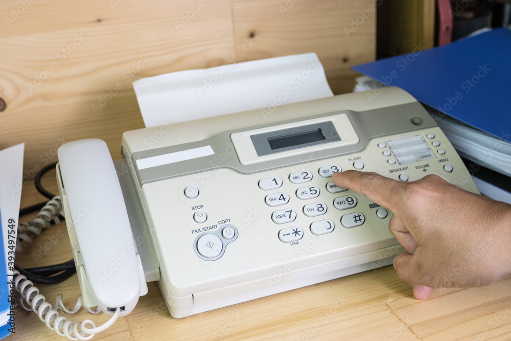 hand man are using a fax machine in the office, equipment for data transmission. hand man are using a fax machine in the office, equipment for data transmission.