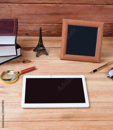 Wooden work table. Laptop and books on the table.