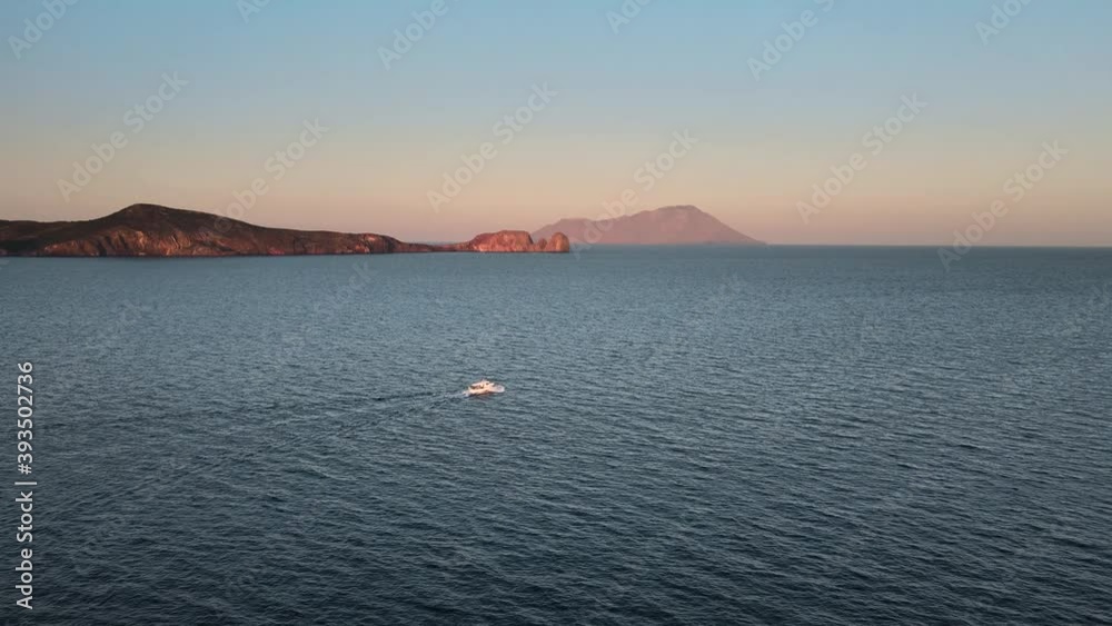 Aerial shot of a boat navigating on mediterranean sea and Greek islands on background Aerial shot of a boat navigating on mediterranean sea and Greek islands on background