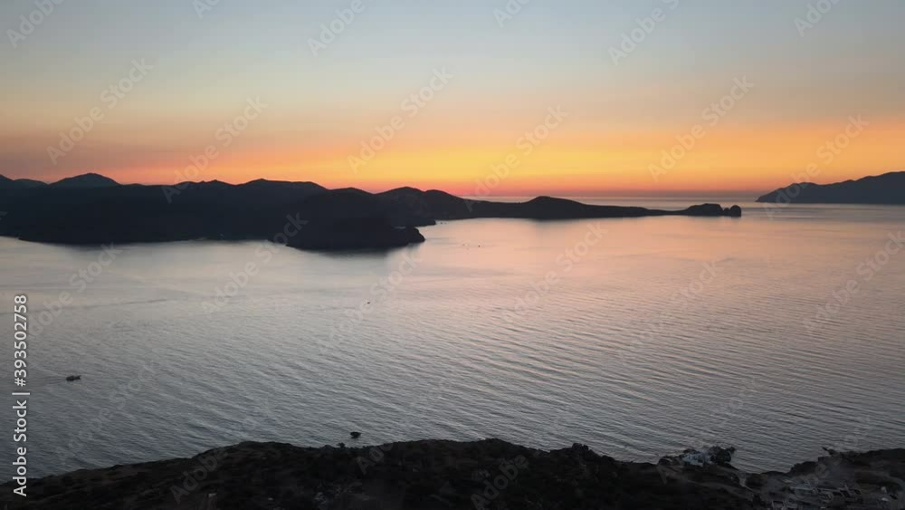 Aerial view of Milos island harbour with an spectacular sunrise sky. Dolly backward Aerial view of Milos island harbour with an spectacular sunrise sky. Dolly backward