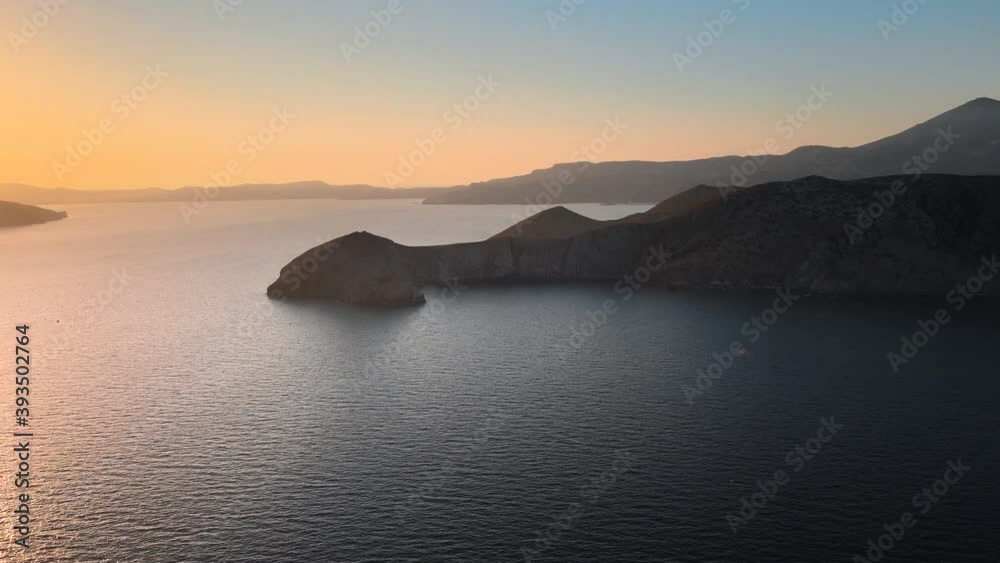 Aerial shot flying towards cliffs on the coastline of Milos island at sunrise Aerial shot flying towards cliffs on the coastline of Milos island at sunrise