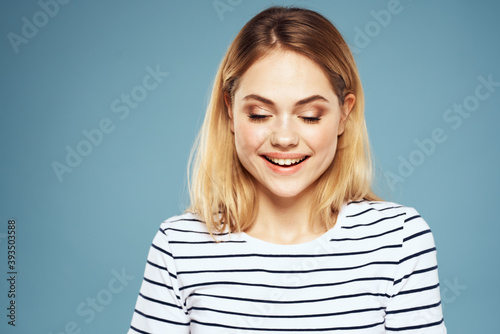 Blonde girl in striped t-shirt lifestyle blue background fun