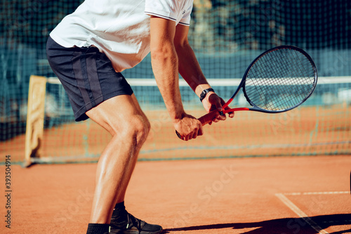Tennis player standing in ready position on tennis court
