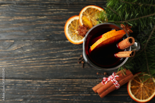 Glass of mulled wine and ingredients on wooden table