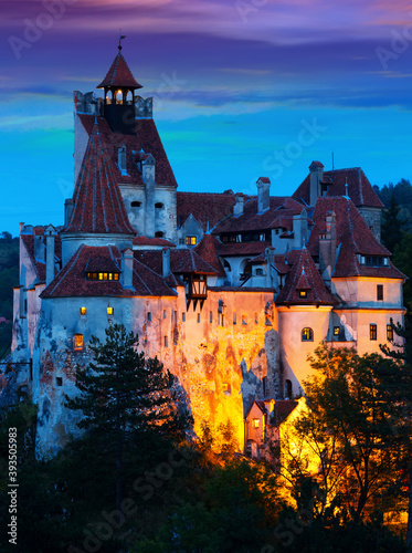 View of main romanian tourist attraction Bran Castle on cliff top on twilight.