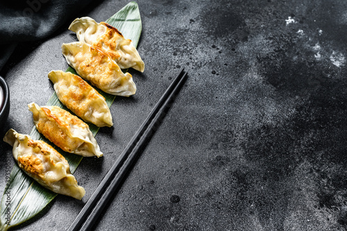 Fried dumplings. Chinese food cooking. Black background. Top view. Copy space