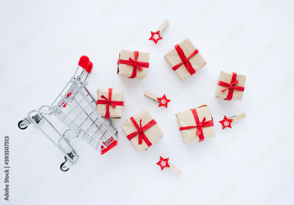 Top view on shopping cart with gifts and christmas decorations scattered on white background. Top view on shopping cart with gifts and christmas decorations scattered on white background.