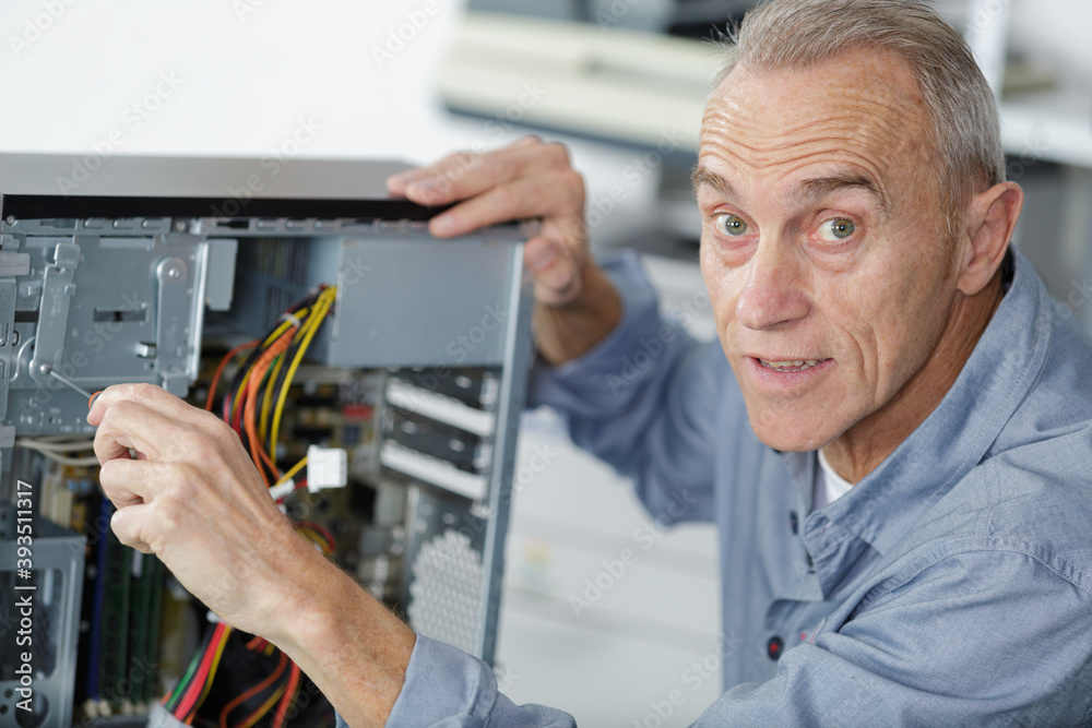 senior man assembling a desktop computer