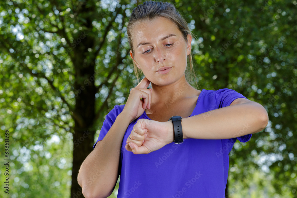 young woman on beach checking heart rate after run young woman on beach checking heart rate after run