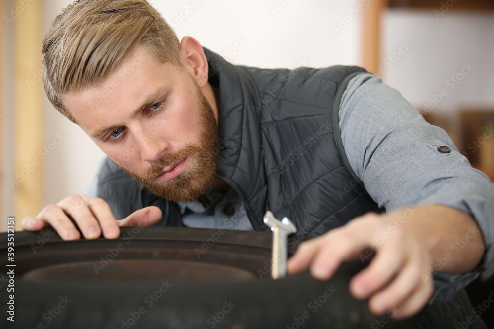 Obraz premium close up of mechanic checking a black tire