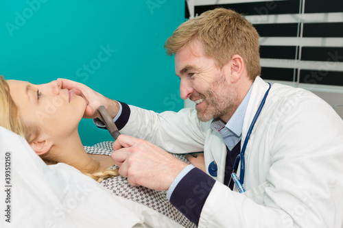 concentrated dermatologist using medical loupe in the clinic