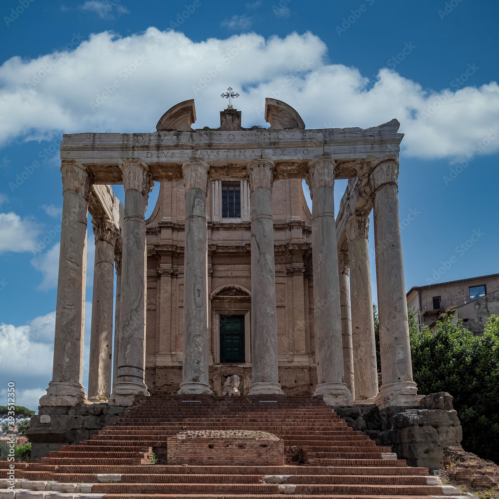 Antonino and Faustina ancient temple facade under an impressive sky in the Roman forum, Rome, Italy.