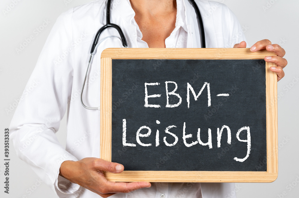 Ärztin mit einer Tafel auf der EBM Leistung steht Ärztin mit einer Tafel auf der EBM Leistung steht