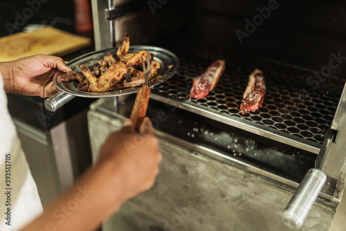 latin american man roasting meat for barbecue. Brazilian Barbecue