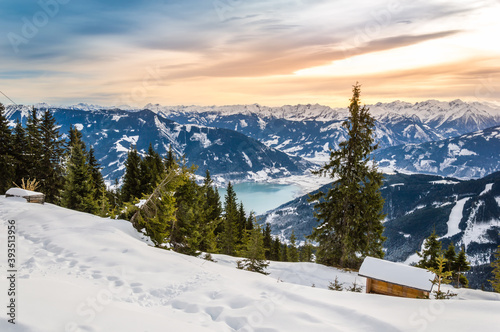 Zell am See and Schmitten town at Zeller lake in winter. View from Schmittenhohe mountain, snowy ski resort slope in the Alps mountains, Austria. Stunning landscape, snow and sunset sky near Kaprun photo