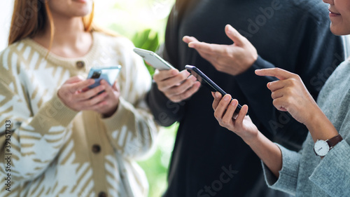 Group of young people using and looking at mobile phone together