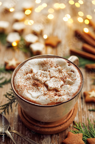 Festive hot chocolate with creamy foam and marshmallow stars sprinkled with aromatic cinnamon close up view