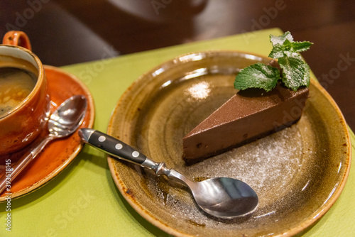 Piece of chocolate cheesecake with berries on dark background, close up photo