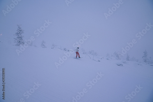 Skateboarder on the slope in snowy weather 