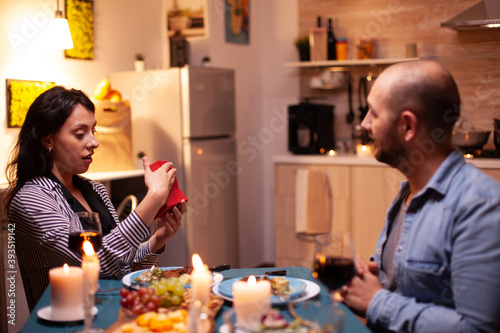 Couple using tablet pc with green template during festive dinner. Husband and wife looking at green screen template chroma key display sitting at the table in kitchen.