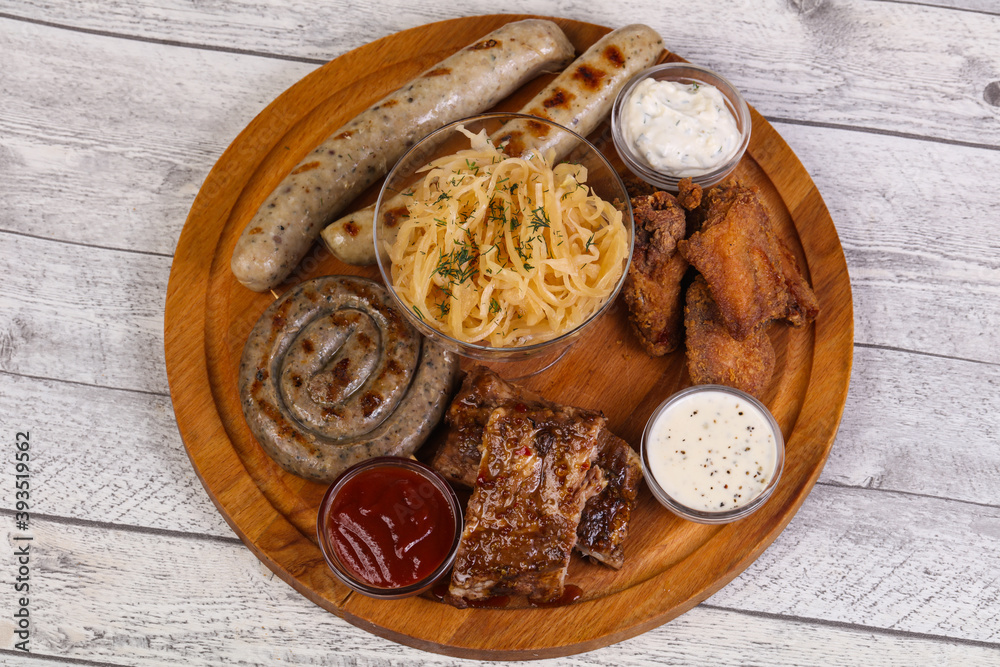 Fototapeta premium Meat plate with grilled sausages, ribs and chicken wings