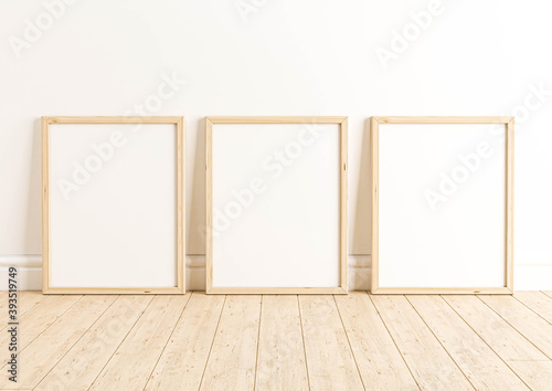 Three Vertical 8x10 Wood Frames Mockup. Three Vertical Wood Frames on a wooden floor and white wall.