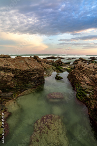 sunrise at the Playa de las Catedrales Beach in Galicia in northern Spain with tidal pools in the foreground