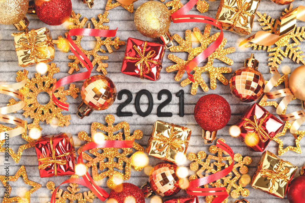 2021 - quote on a felt letter board. Festive concept with red and gold glittering toys and confetti.