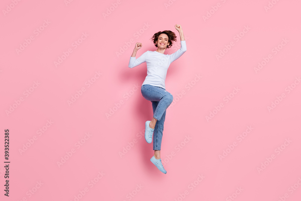 Full size photo of cheerful girl win jump raise fists wear pullover gumshoes isolated pink color background
