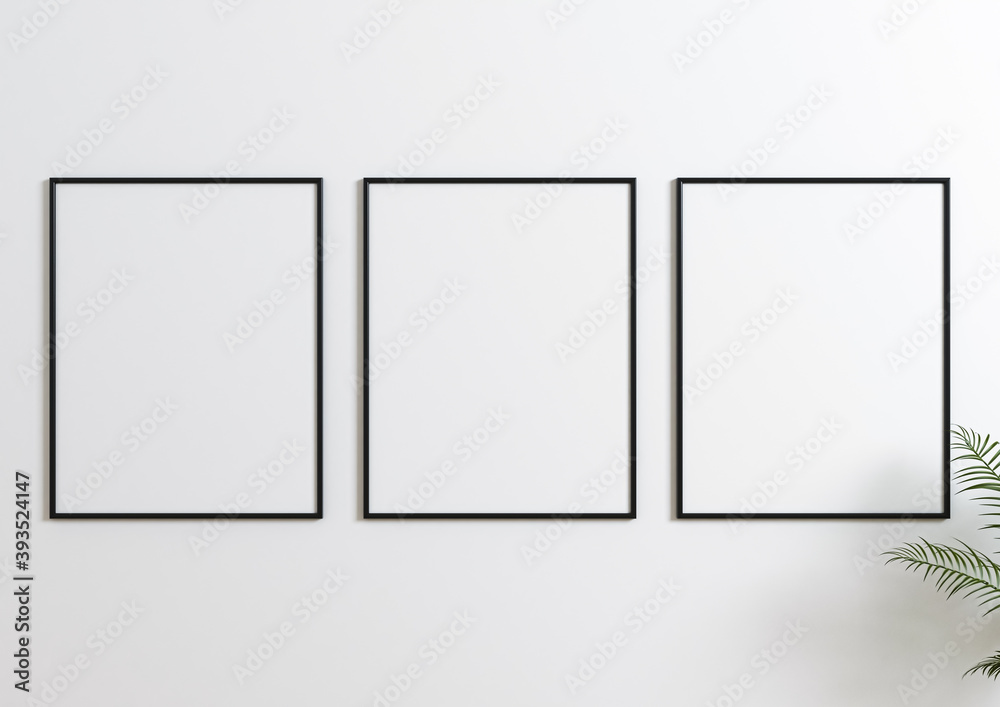 Three Vertical 8x10 Black Frame mockup. Three Vertical Black frames on a white wall with plant leaves. Three Vertical 8x10 Black Frame mockup. Three Vertical Black frames on a white wall with plant leaves.