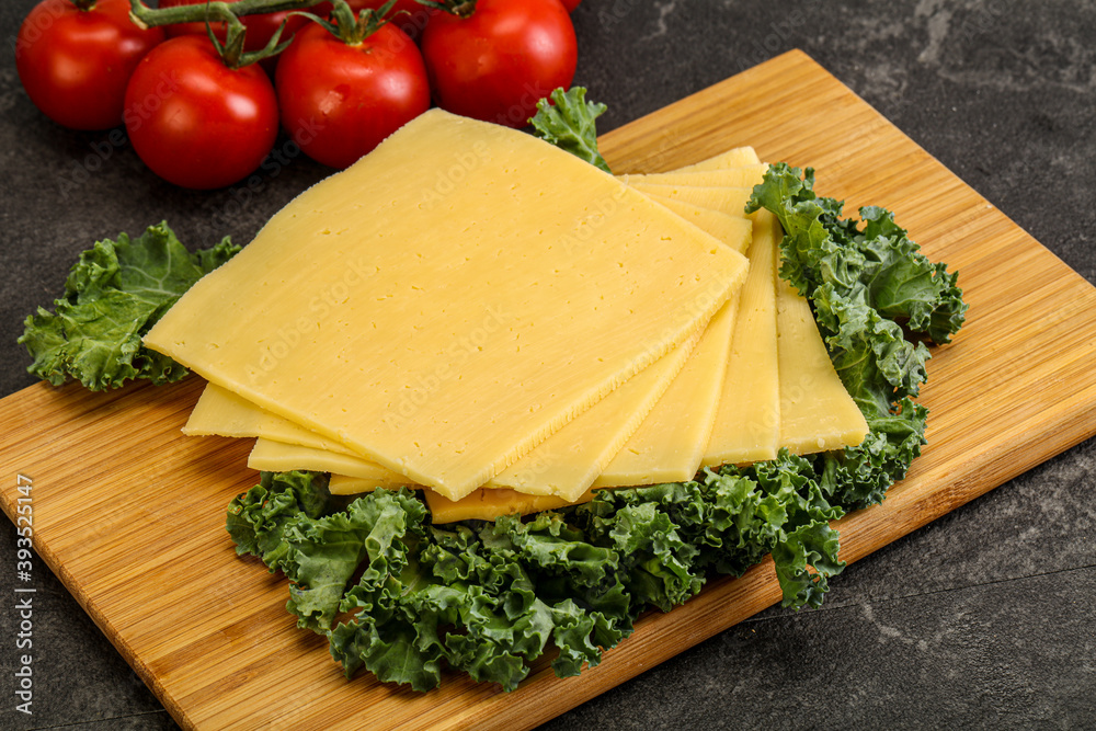 Sliced Gauda cheese over board Sliced Gauda cheese over board