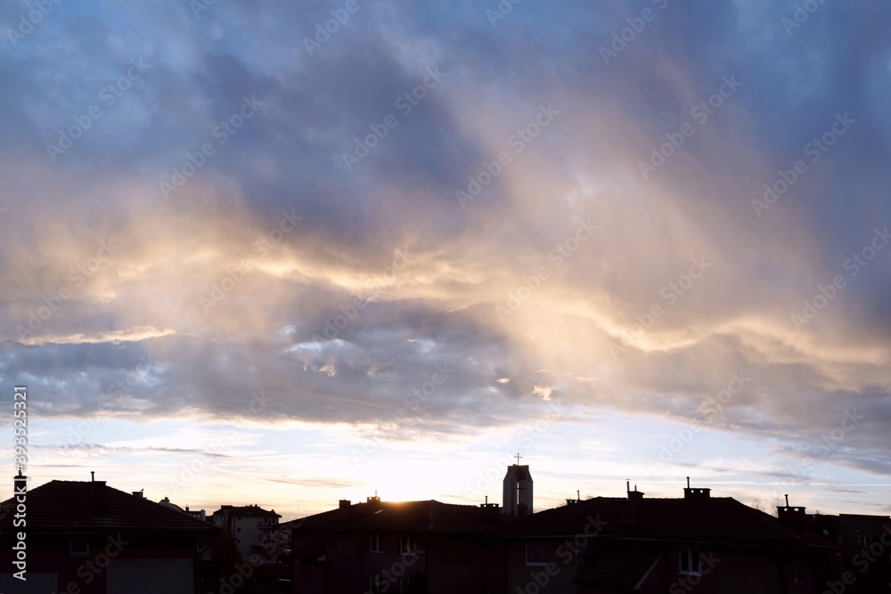 Beautiful cityscape with dark silhouette of town on horizon and colorful clouds with light during sunrise. Beautiful cityscape with dark silhouette of town on horizon and colorful clouds with light during sunrise.