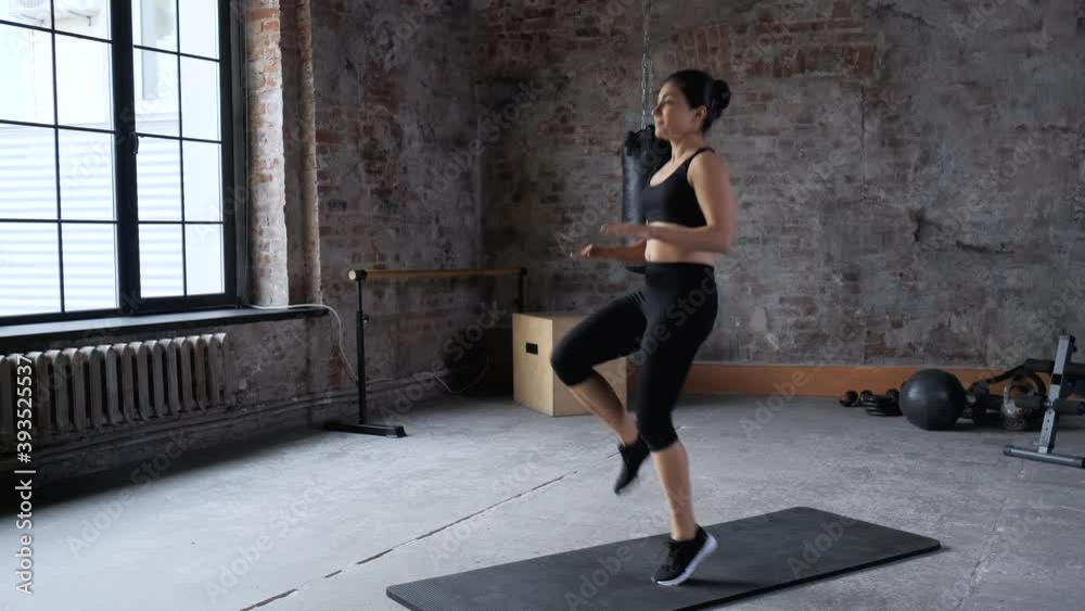 Young Indian Athletic Woman Jumps Sports Does Exercise Dressed in Sportswear Black Top and Leggings, is In the Gym Young Indian Athletic Woman Jumps Sports Does Exercise Dressed in Sportswear Black Top and Leggings, is In the Gym