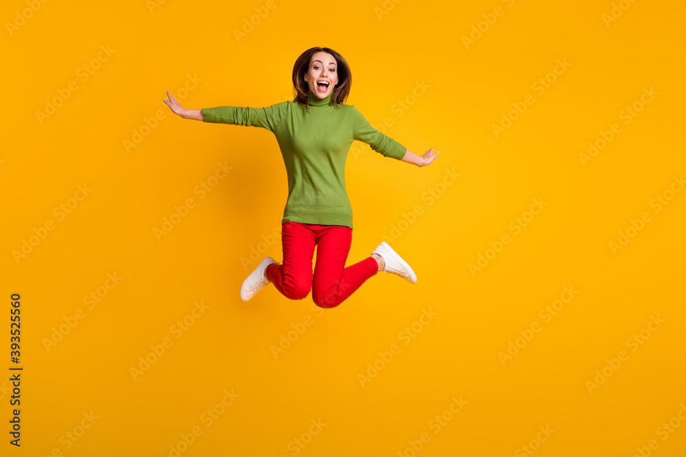 Full body photo of lady jump up air flight rejoicing wear casual pullover sneakers red trousers isolated yellow color background